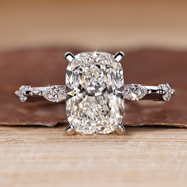 Elongated cushion cut diamond ring with distance pave setting and hidden halo.