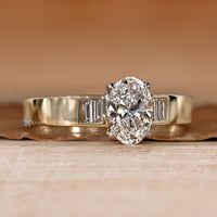 Oval cut diamond ring with four claw prongs.