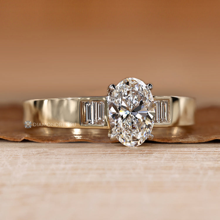 Oval cut diamond ring with four claw prongs.