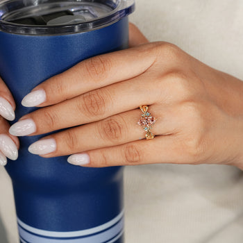 Pink center diamond ring with blue round side stones.