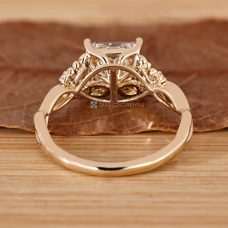 Princess cut diamond ring with a twisted shank and round side stones.