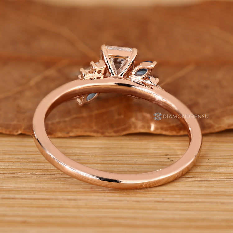 Asymmetrical cluster ring with round side stones and blue sapphires.