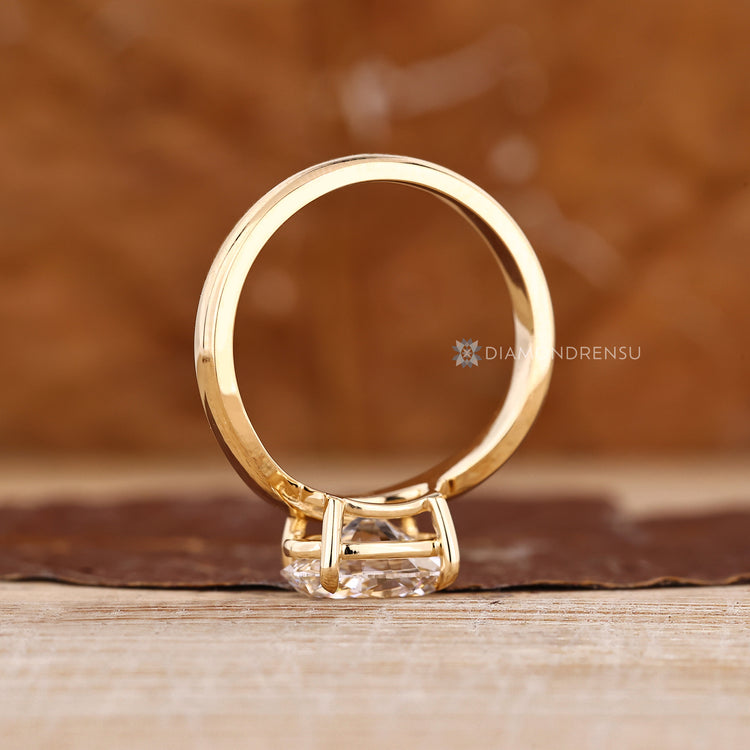 Oval diamond ring with four claw prongs and modern style.