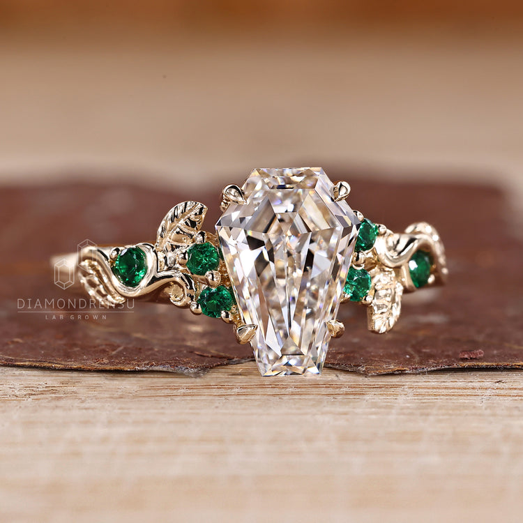 IGI certified coffin cut diamond ring with emerald accents.