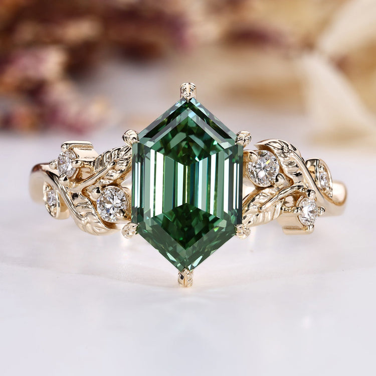 Hexagon diamond ring with green center stone and round side stones.