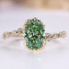 Green oval engagement ring with round side stones.