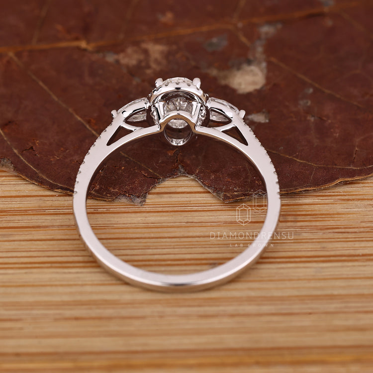 Oval diamond ring with cathedral setting and pear stones.