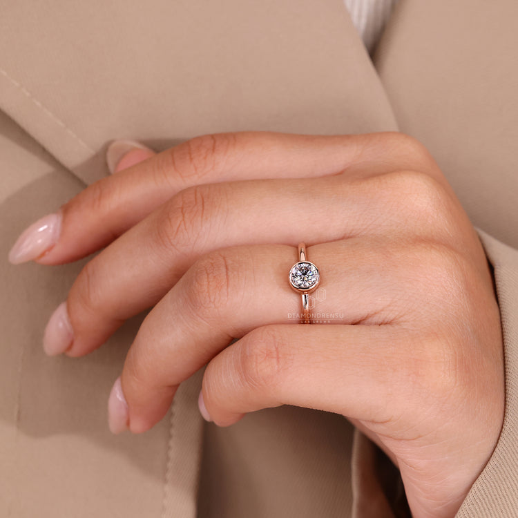 Handmade round cut diamond ring in bezel setting.