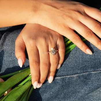Nature inspired marquise diamond ring with round accents.