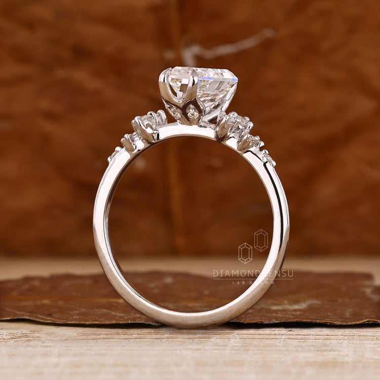 Coffin cut diamond ring with four claw prongs and side stones.