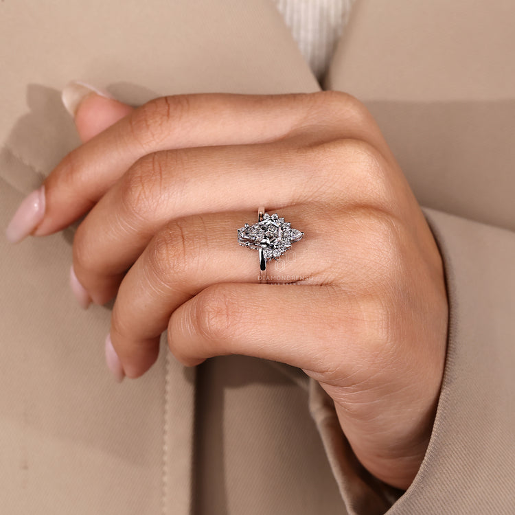 Coffin shaped engagement ring with four prongs and halo accents.