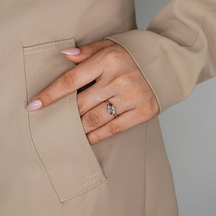Emerald center stone ring with marquise-cut blue sapphires.