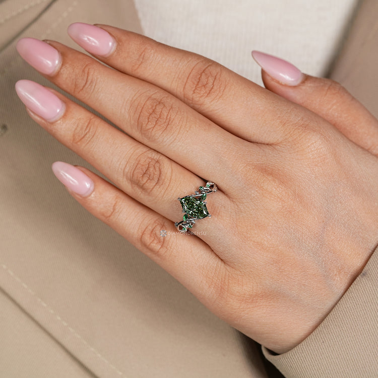 Diamondrensu presents a Dutch marquise diamond ring with green emerald side stones.