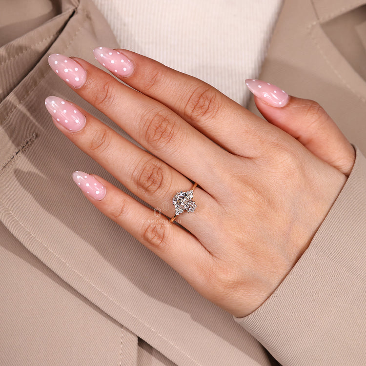 Coffin center stone ring with round side stone accents.