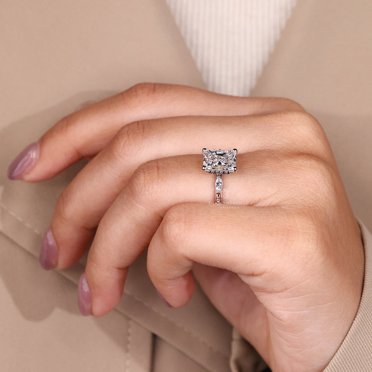 Custom diamond ring with radiant cut diamond and distance pave halo design.
