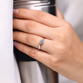 Solitaire setting ring holding round diamond with pinched shank design.
