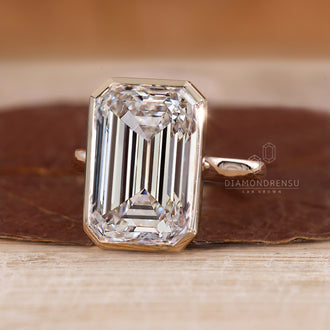 Solitaire diamond ring with emerald cut stone.
