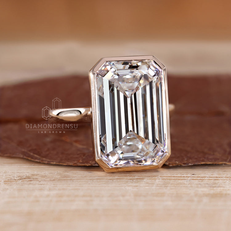 Custom diamond ring with bezel set emerald cut.
