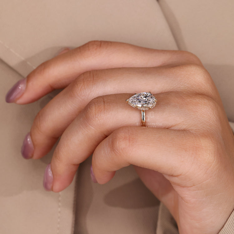 Yellow gold engagement ring with hidden halo and delicate leaf style setting.
