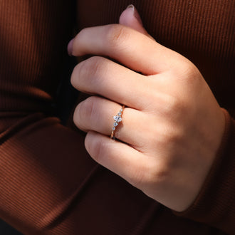 Round cut side stone engagement ring featuring 6 prong yellow gold band.
