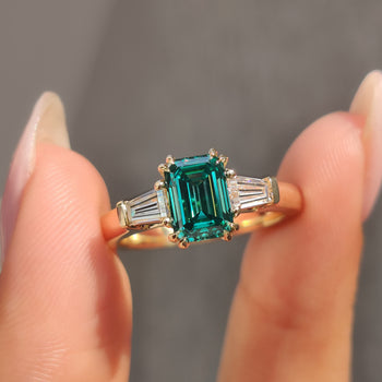 Emerald Cut Moissanite Ring with 2 Tapered Baguette Side Stone, set in a Double Claw Prong for a timeless look.
