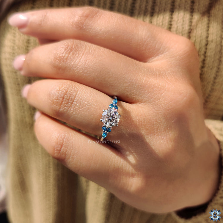 Round moissanite engagement ring white gold ring claw prongs.
