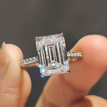 Elegant emerald white gold ring displayed on a velvet box.
