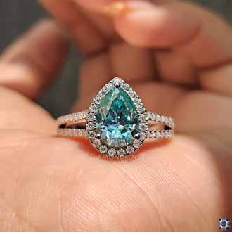 Split pave engagement ring featuring a pear-shaped moissanite center.
