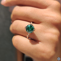 Round cut side stones sparkle on a fishtail prong setting ring.