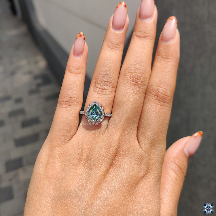 Diamondrensu Ring with a pave ring setting and cyan blue Moissanite.

