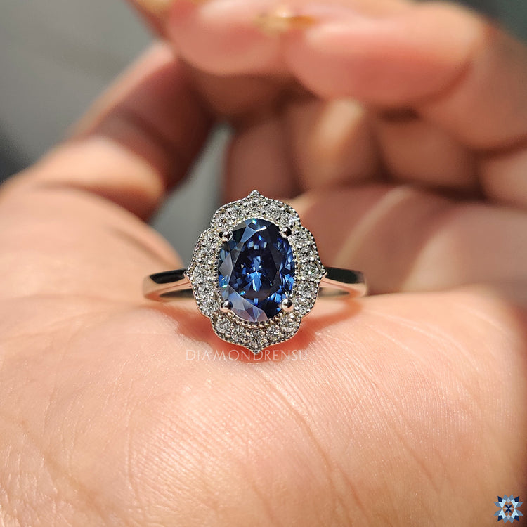 Round Cut Moissanite Ring set in a vintage halo design with milgrain detailing.

