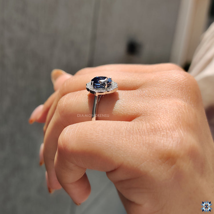Vintage engagement ring featuring a blue Oval Cut Moissanite in a halo setting.
