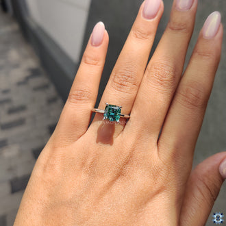 Simple solitaire engagement ring featuring a cushion cut moissanite stone, perfect for a minimalist look.
