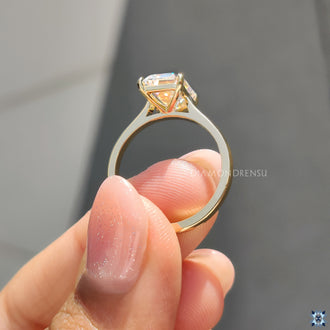 Four claw prong setting ring, securing the emerald cut moissanite stone with stability and style.
