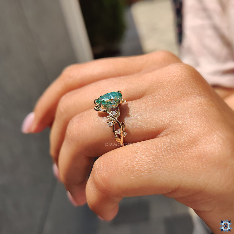 Round side stone ring, combining a pear cut center stone with beautifully crafted side stones.
