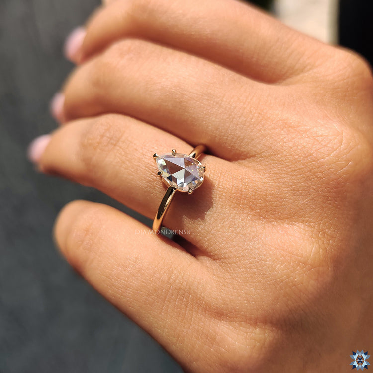 Moissanite engagement ring set in yellow gold with a solitaire design.
