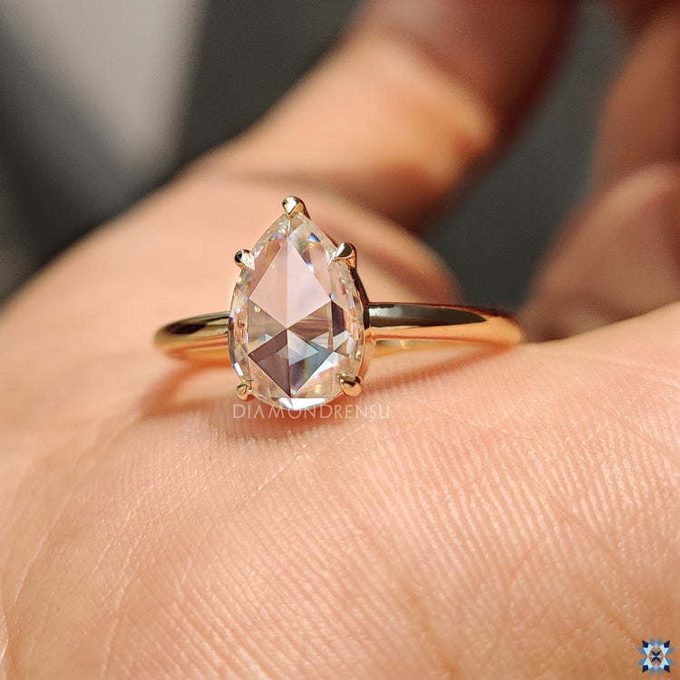 Handmade ring featuring a pear rose cut moissanite stone.
