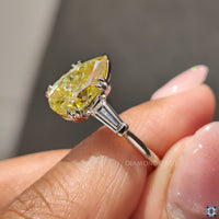 White gold three stone ring with pear cut moissanite.
