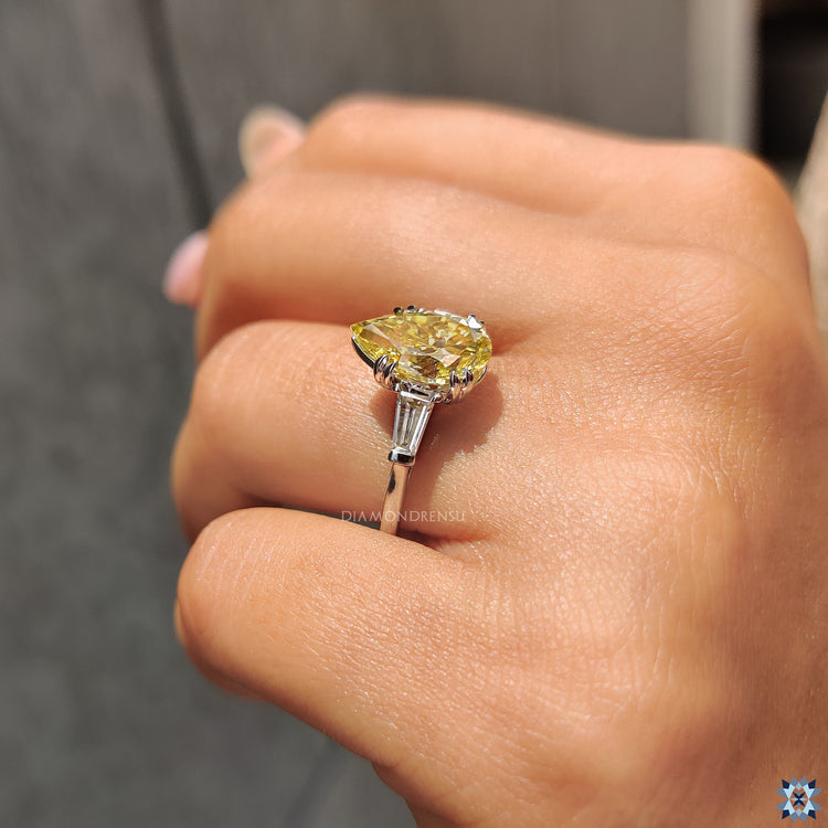 Three stone engagement ring in white gold with side baguettes.
