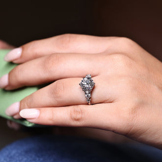 Round diamond ring with pear side stones on each side.
