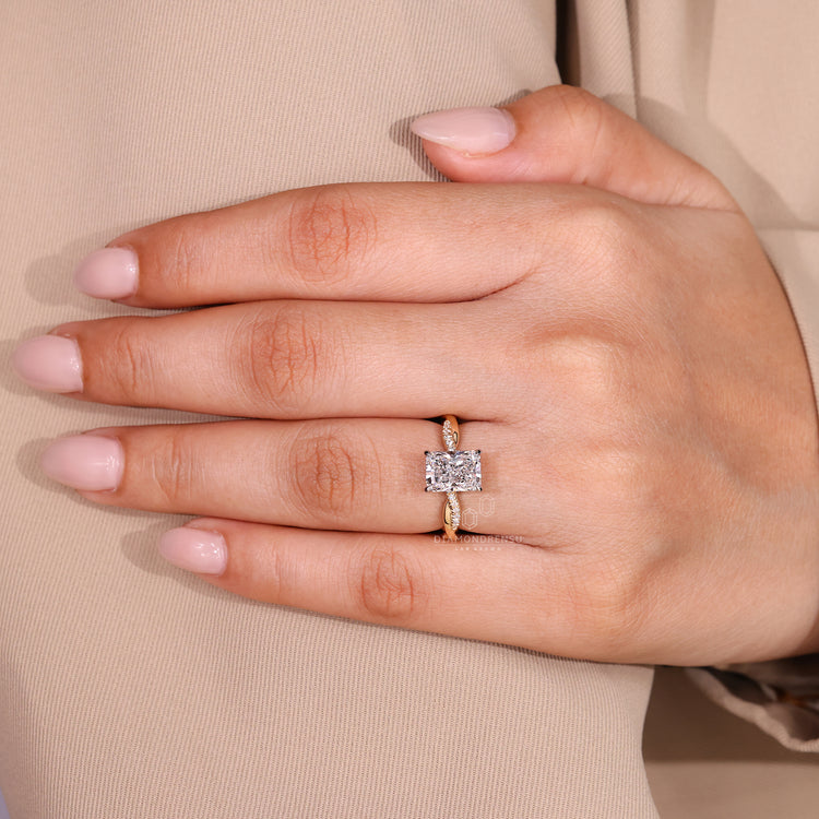 Two tone yellow and white gold engagement ring with pave band and radiant cut diamond.
