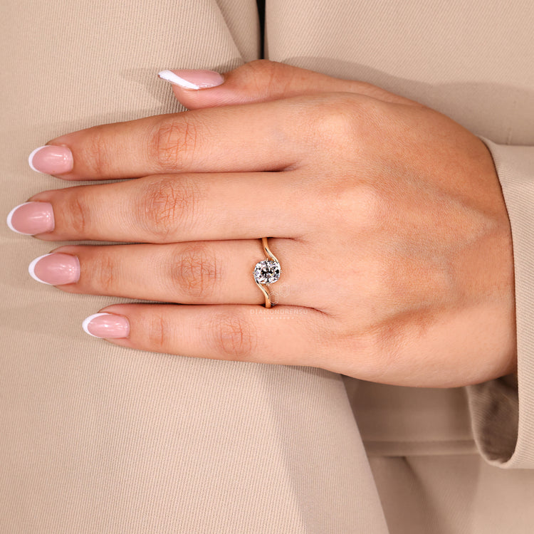 Custom engagement ring with cushion OEC diamond and leaf style prongs.
