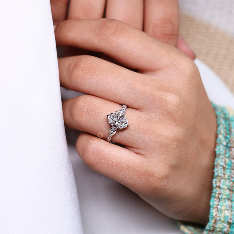 Pear and round side diamond ring with oval cut center stone.
