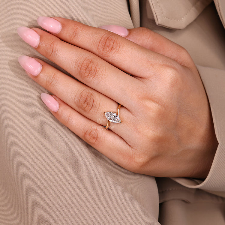 Solitaire marquise diamond ring with compass prong mount.