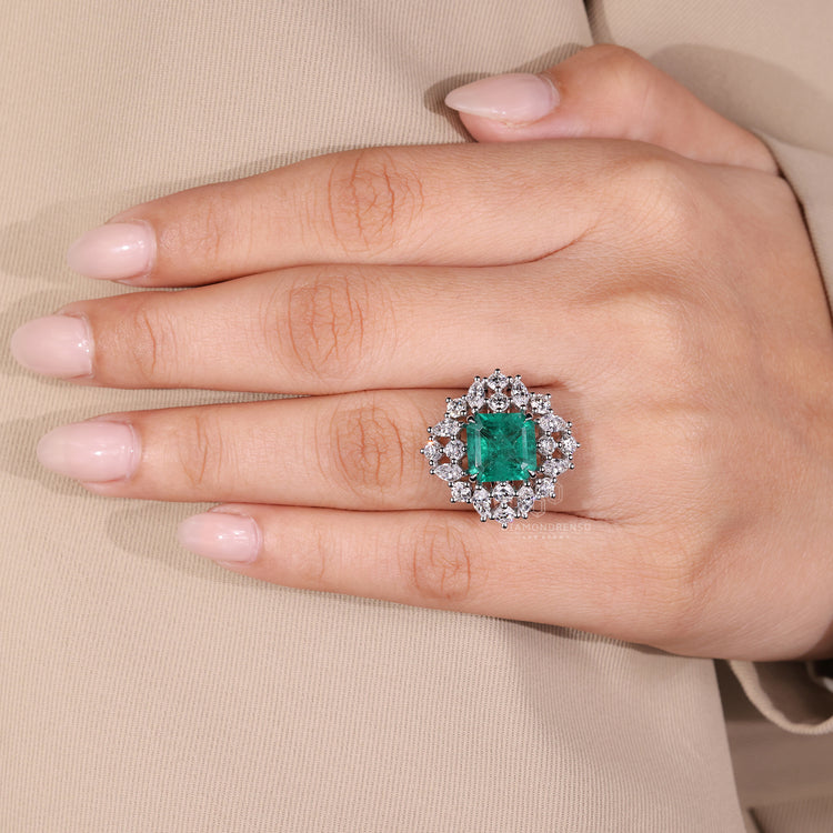 Elegant cluster halo emerald gemstone ring.
