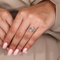Diamond ring with marquise and round diamond side stones in a cluster setting with 6 claw prong setting.
