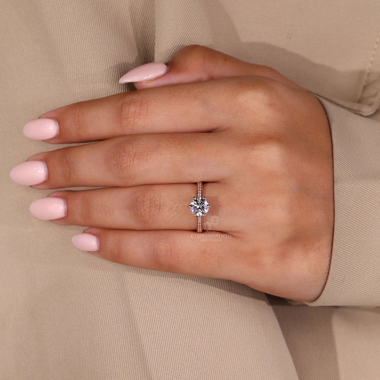 A round cut diamond set in a rose gold band

