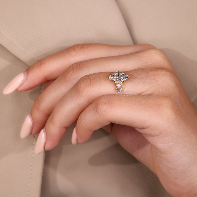 Yellow gold ring with marquise engagement diamond and side stones.
