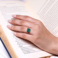 Emerald birthstone ring with diamond accents.
