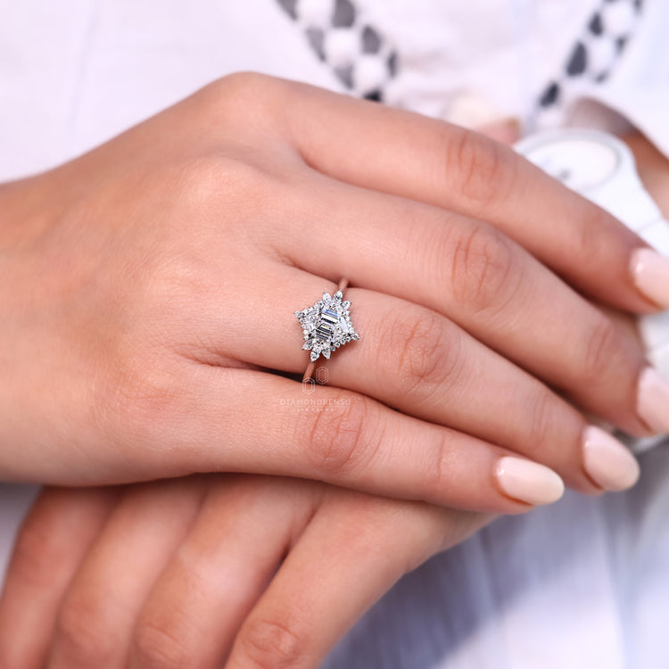 Round engagement ring with side stones and tapered shank.
